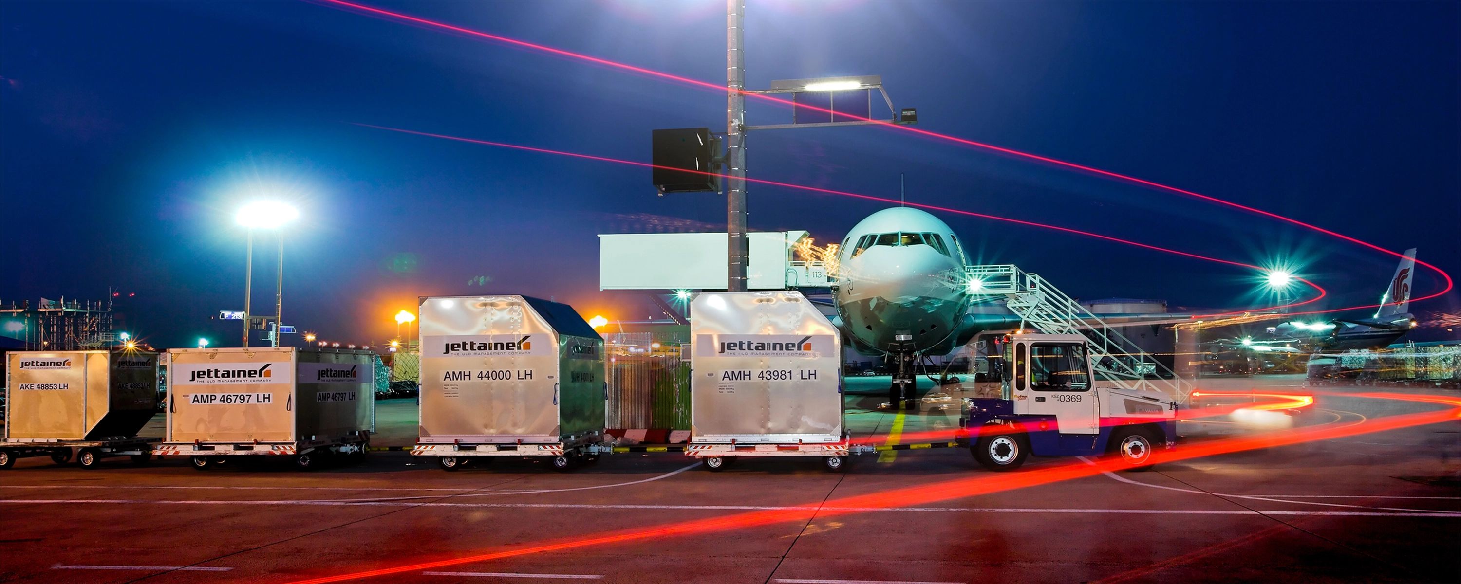 Nachtaufnahme eines Flughafens mit Jettainer‑ULD‑Containern – effiziente Luftfrachtabfertigung und Ladeeinheiten‑Management im internationalen Flugverkehr.