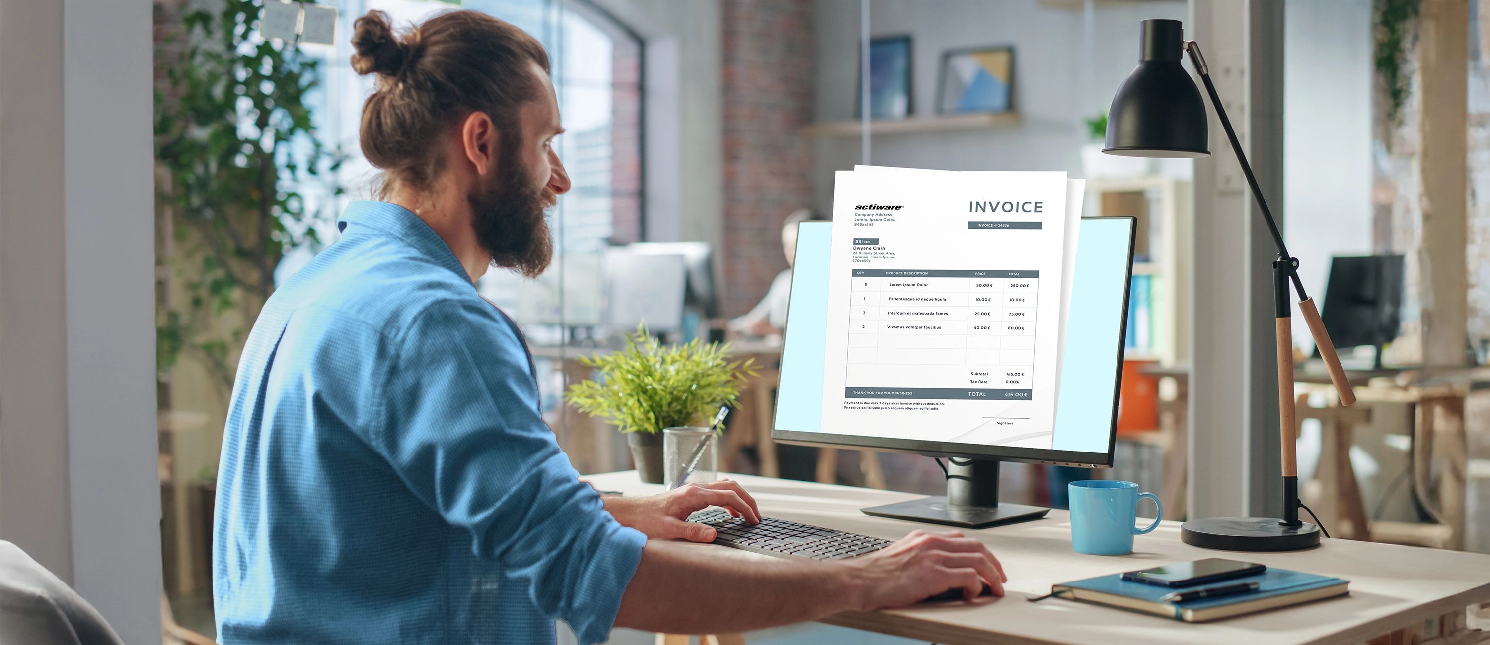 Ein Mann mit einem blauen Hemd sitzt in einem hellen Büro an einem Schreibtisch. Auf dem Computerbildschirm vor ihm ist groß eine digitale Rechnung (Invoice) im PDF-Format eingeblendet, während er tippt.