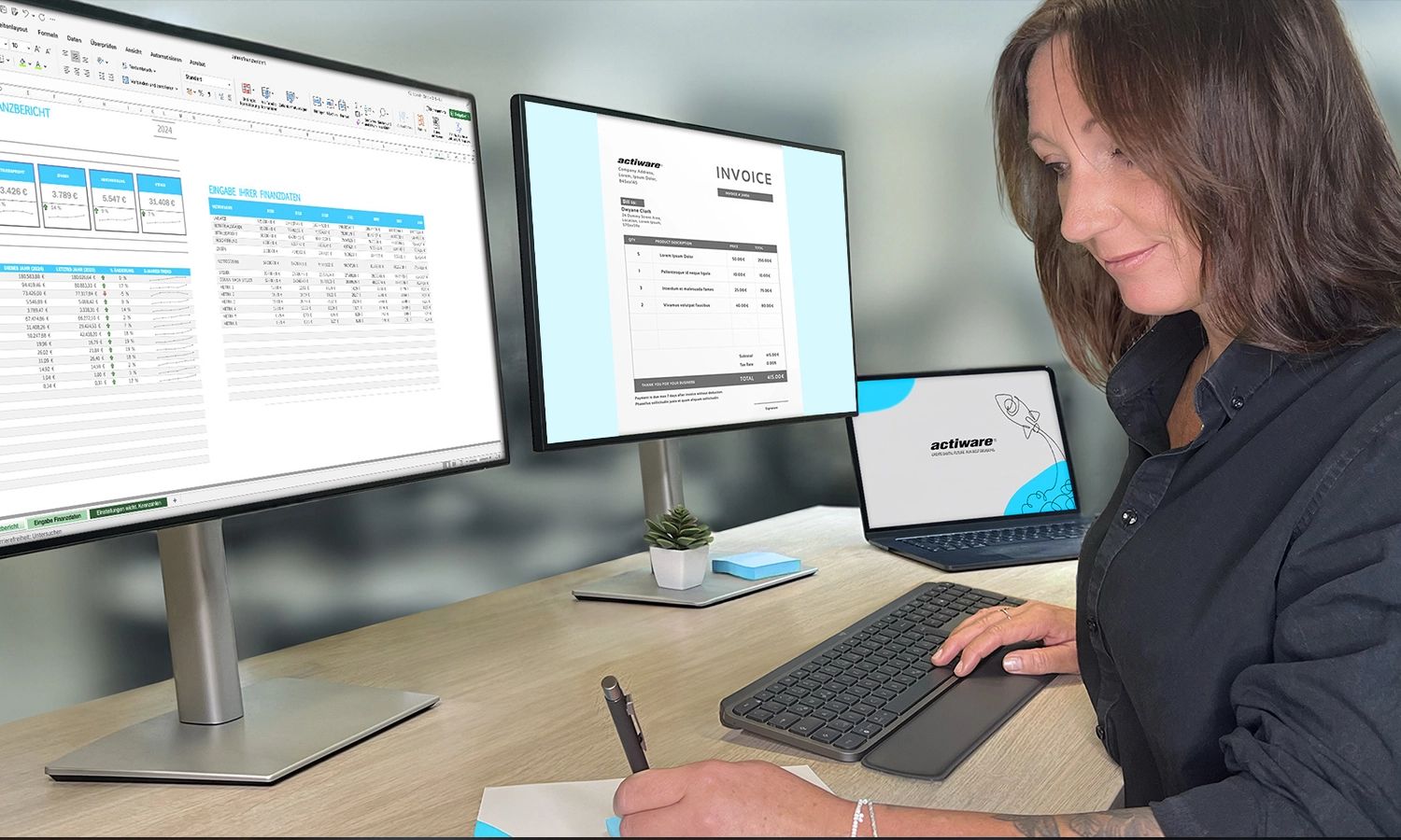 Eine konzentrierte Frau sitzt an einem Schreibtisch und macht Notizen, während sie vor zwei Monitoren arbeitet. Der rechte Monitor zeigt eine digitale Rechnung mit dem actiware-Logo (als 'INVOICE' betitelt), der linke Monitor zeigt Tabellenkalkulationen und Daten. Im Hintergrund ist zusätzlich ein Laptop mit einem ACTIWARE-Hintergrund sichtbar.