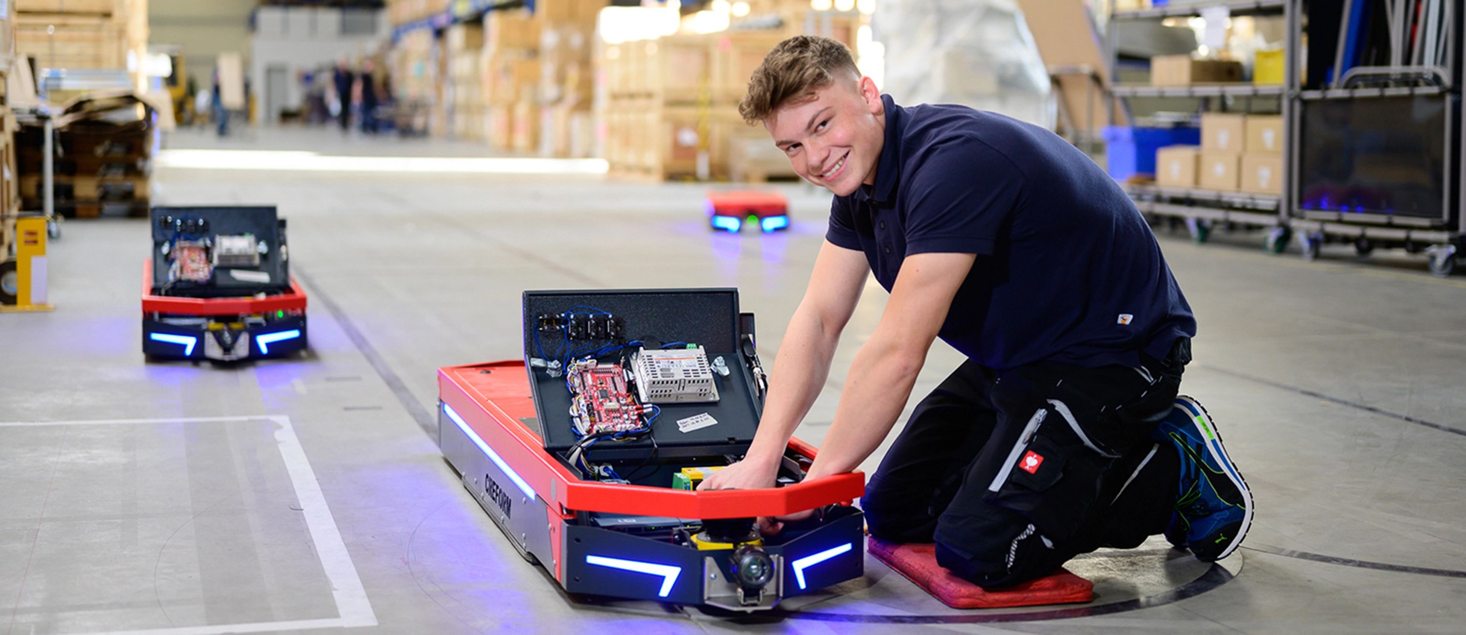 Mitarbeiter der Firma Creform arbeitet in der Werkhalle an einem fahrerlosen Transportsystem – innovative Intralogistik und Automatisierungstechnik im Einsatz.