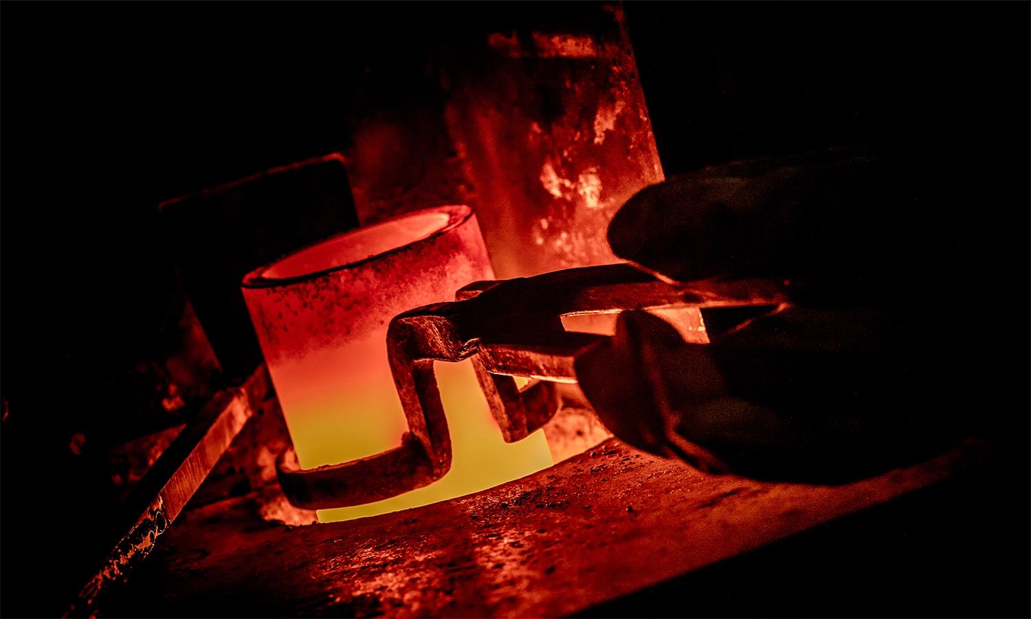 Glühender Schmelztiegel mit geschmolzenem Metall – Symbol für den Schmelzprozess in der Edelmetallproduktion von Heimerle + Meule und für präzise Metallverarbeitung in hoher Qualität.