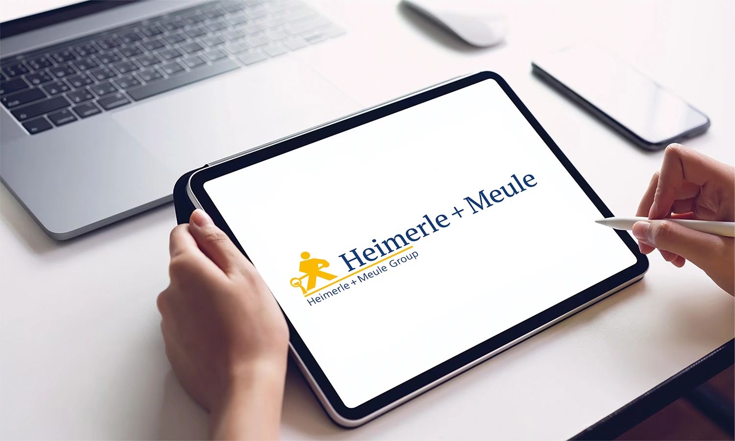 Tablet mit Heimerle + Meule Logo – Darstellung der Marke des traditionsreichen Edelmetallunternehmens für digitale Kommunikation, Innovation und moderne Unternehmensdarstellung.