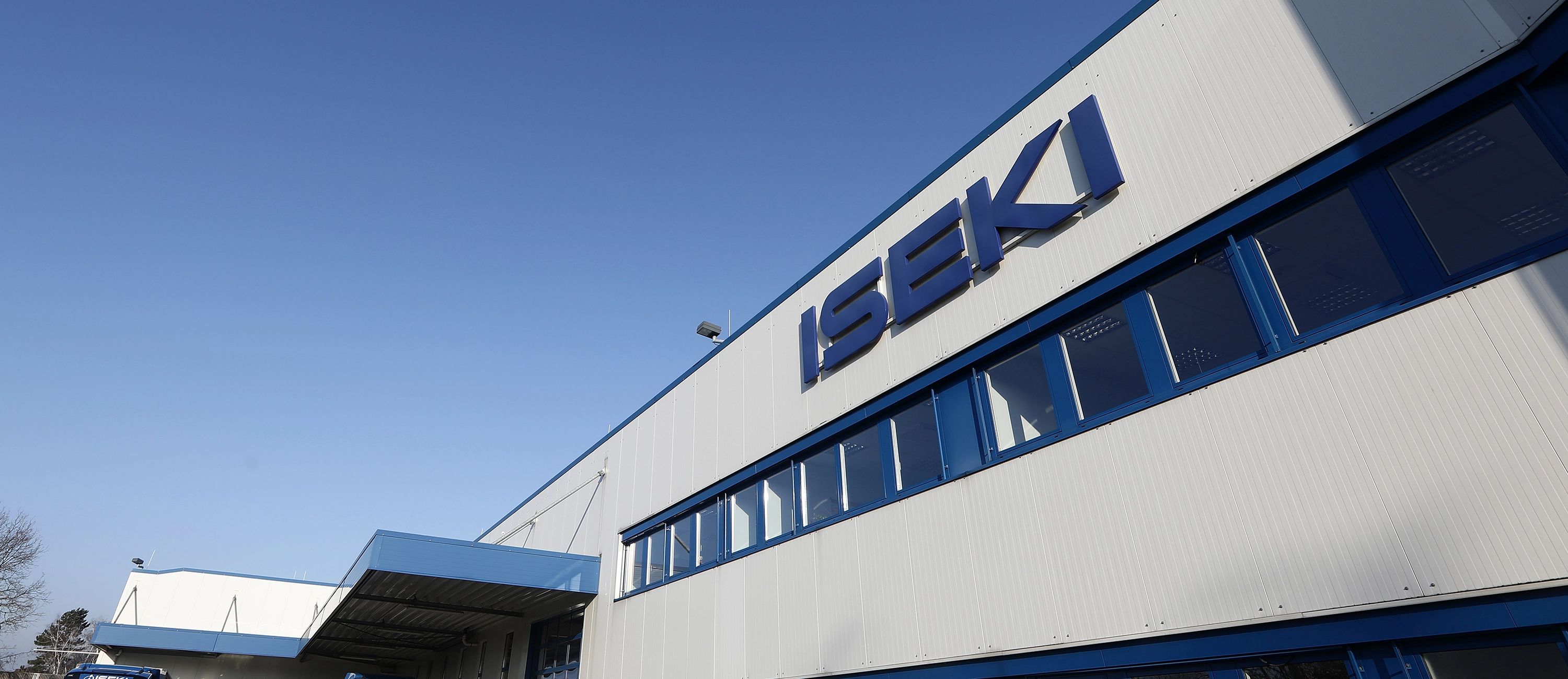 Firmengebäude von Iseki – moderne Industriehalle mit Unternehmenslogo, Standort des Spezialisten für Kommunal‑ und Landtechnikmaschinen.