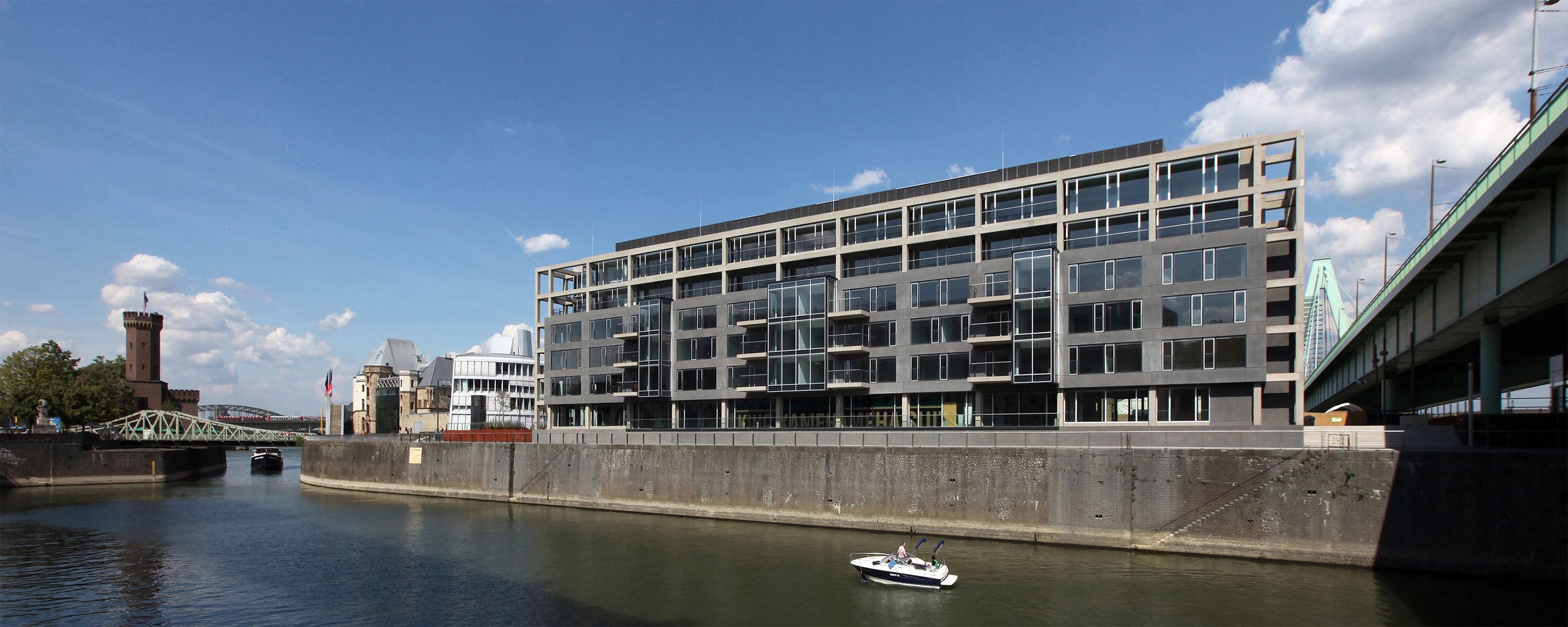 Reclay‑Firmensitz an einem modernen Bürogebäude am Rheinufer – Standort des internationalen Umweltdienstleisters für Recycling und Kreislaufwirtschaft.