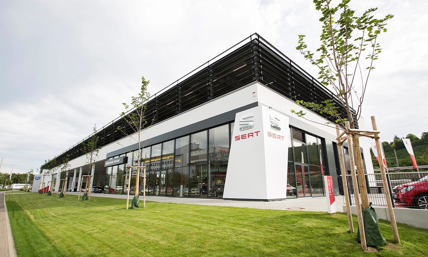 Modernes SEAT‑Autohaus mit Glasfassade und markantem Logo – Außenansicht eines Verkaufs‑ und Servicezentrums der Automarke SEAT.
