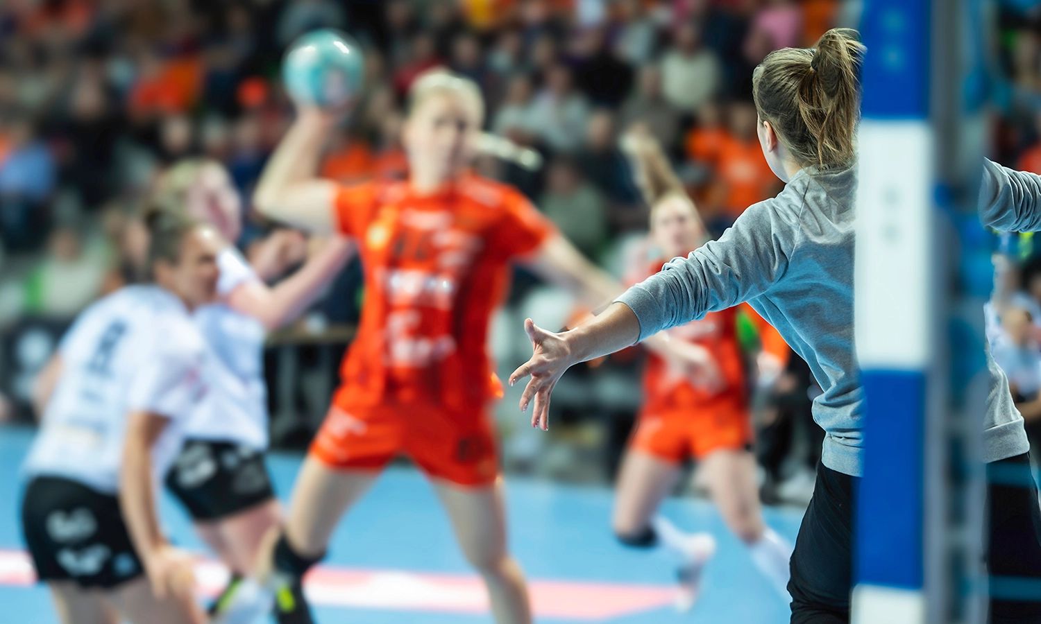 Menschen spielen gemeinsam Mannschaftssport auf einem Spielfeld.