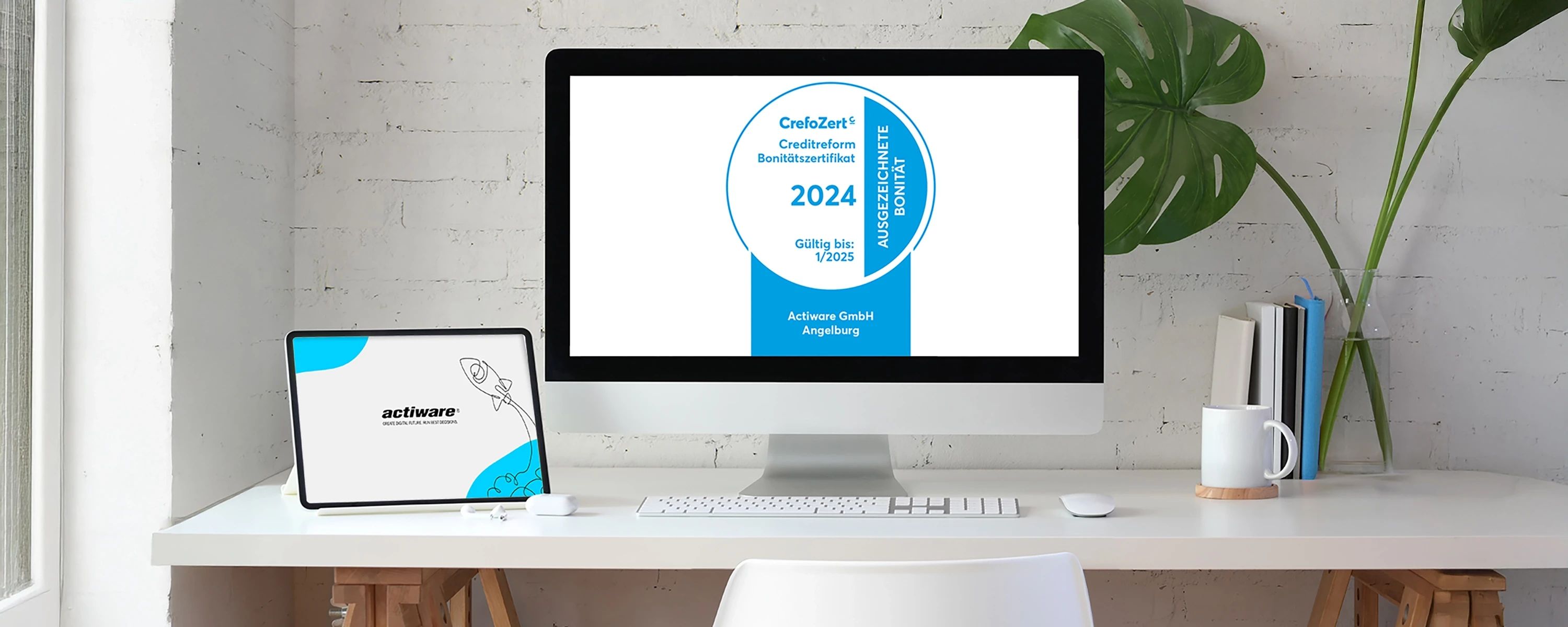 Das CrefoZert Bonitätszertifikat 2024 von Creditreform für die actiware GmbH wird auf einem Computerbildschirm an einem aufgeräumten, modernen Arbeitsplatz angezeigt. Links daneben steht ein Tablet, das ebenfalls das actiware-Logo zeigt.