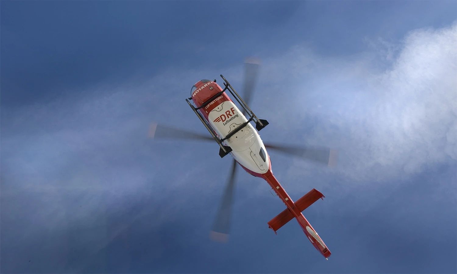 Rettungshubschrauber der DRF Luftrettung im Flug vor blauem Himmel – modernste Luftfahrttechnik für schnelle Notfalleinsätze.