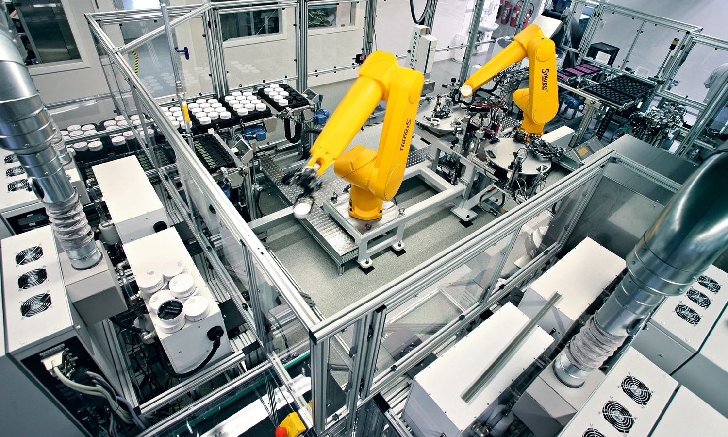Automatisierte Fertigungsanlage bei Hekatron – industrielle Produktionslinie mit zwei Roboterarmen für präzise Montage von Komponenten in der Brandschutztechnik.