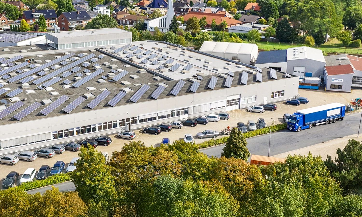 Produktionsgebäude der Firma Herzog – moderne Industriehalle mit Solaranlage auf dem Dach, Symbol für nachhaltige Fertigung, Energieeffizienz und technologische Innovation.