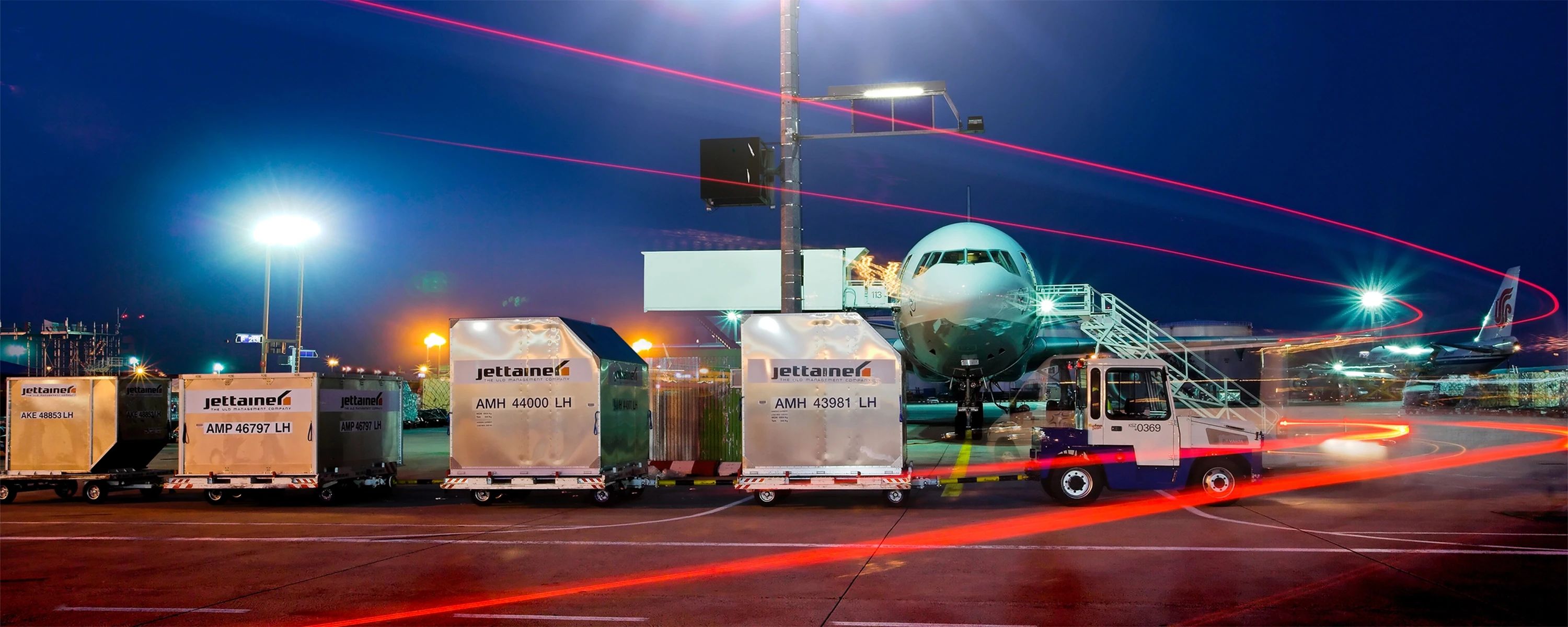 Nachtaufnahme eines Flughafens mit Jettainer‑ULD‑Containern – effiziente Luftfrachtabfertigung und Ladeeinheiten‑Management im internationalen Flugverkehr.