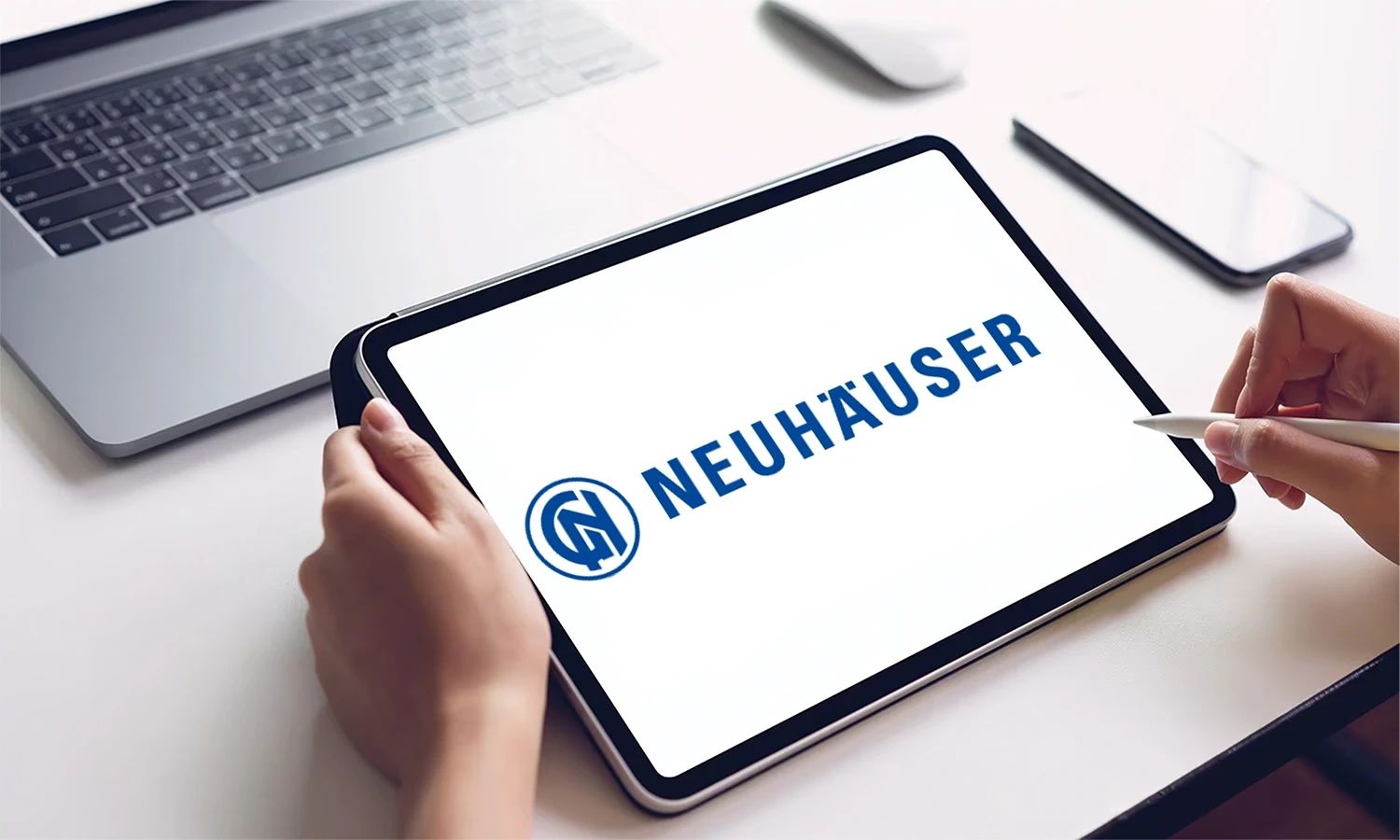 Tablet mit Neuhäuser‑Logo – Symbol für Präzisionswerkzeuge, Technologiekompetenz und Innovation im Maschinen‑ und Werkzeugbau.