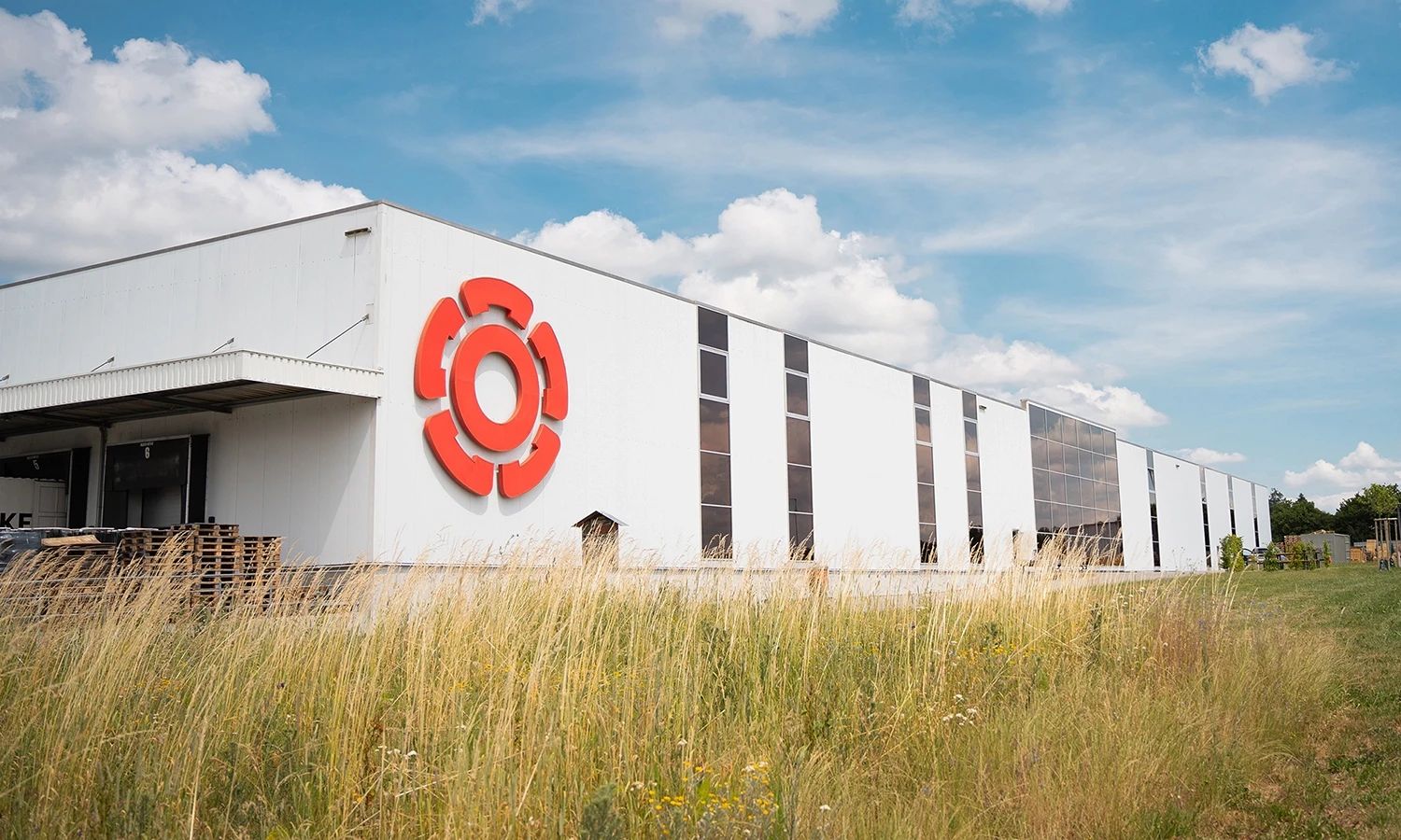 Rosenberg‑Firmengebäude mit großem roten Logo an der Fassade – moderner Produktions‑ und Logistikstandort des Lüftungs‑ und Klimatechnikherstellers.