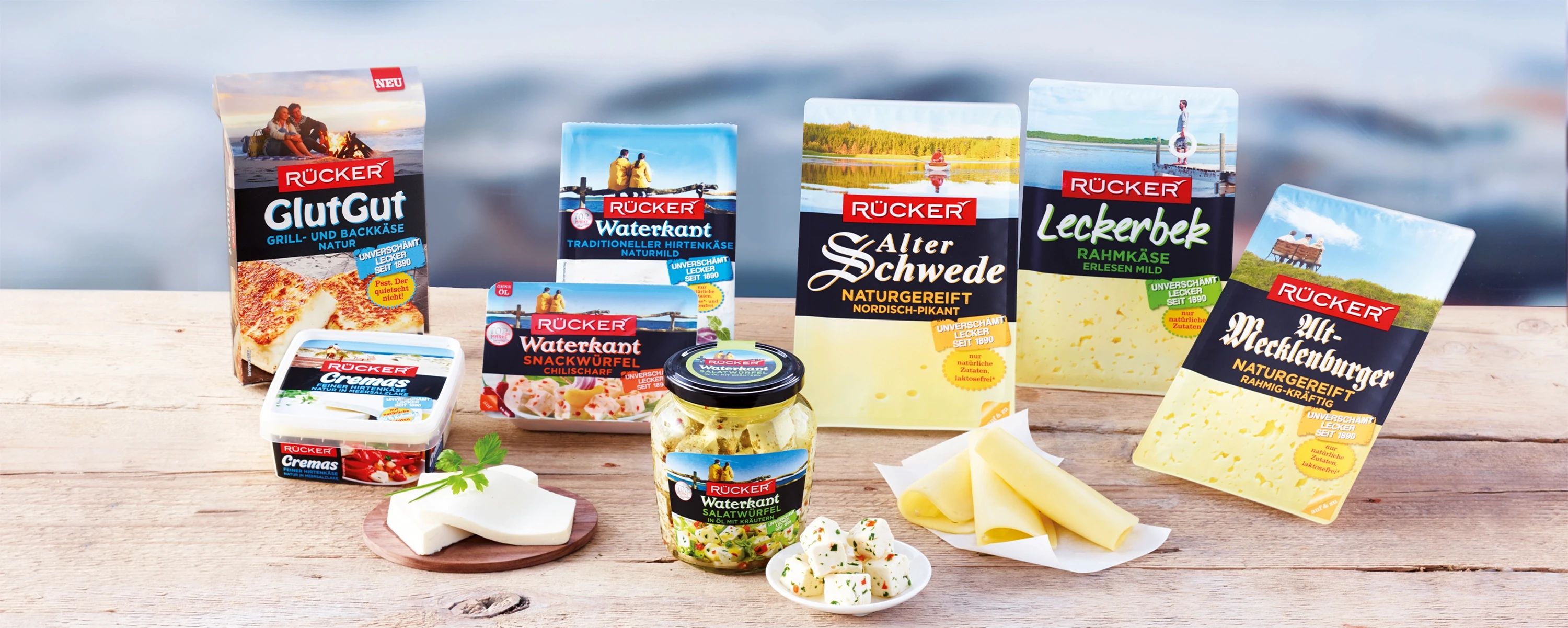 Sortiment verschiedener Rücker‑Käseprodukte auf Holztisch – norddeutsche Spezialitäten wie Alter Schwede, Waterkant und Alt‑Mecklenburger zeigen die Vielfalt der Molkerei Rücker.
