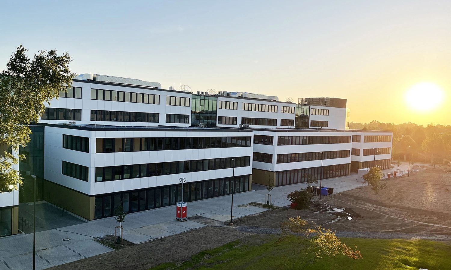 Firmengebäude von ACTIWARE Development im Sonnenaufgang, moderne Glas- und Fassadenarchitektur