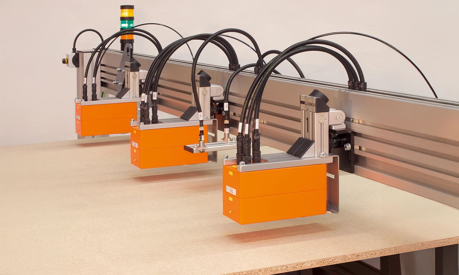 Messsystem von Fagus GreCon mit drei orangefarbenen Sensoren – präzise industrielle Messtechnik zur Qualitätskontrolle und Dickenmessung von Plattenmaterial.