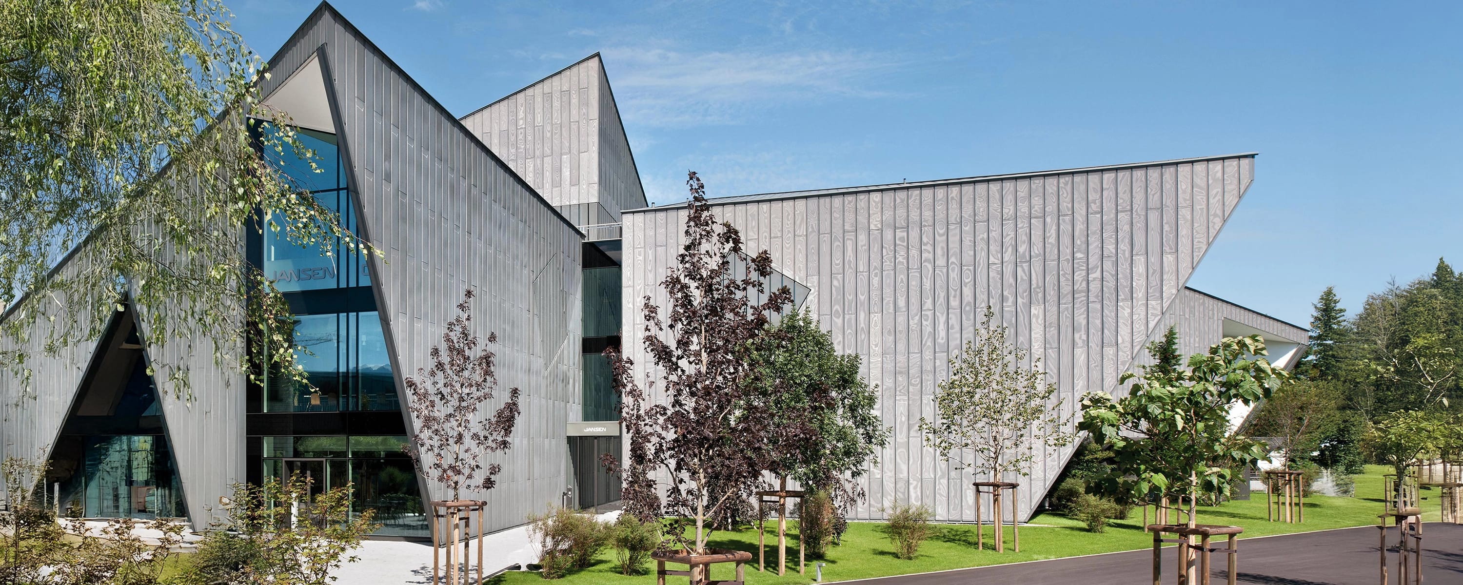 Moderne Architektur mit Jansen‑Stahlsystemen – beeindruckendes Gebäude mit geometrischer Fassade und großflächigen Glas‑ und Metallelementen.