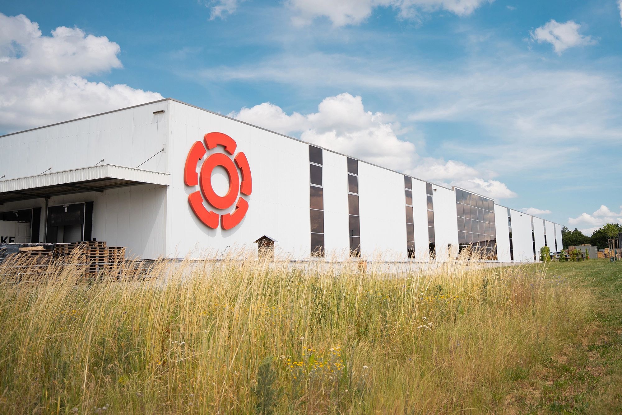 Rosenberg‑Firmengebäude mit großem roten Logo an der Fassade – moderner Produktions‑ und Logistikstandort des Lüftungs‑ und Klimatechnikherstellers.