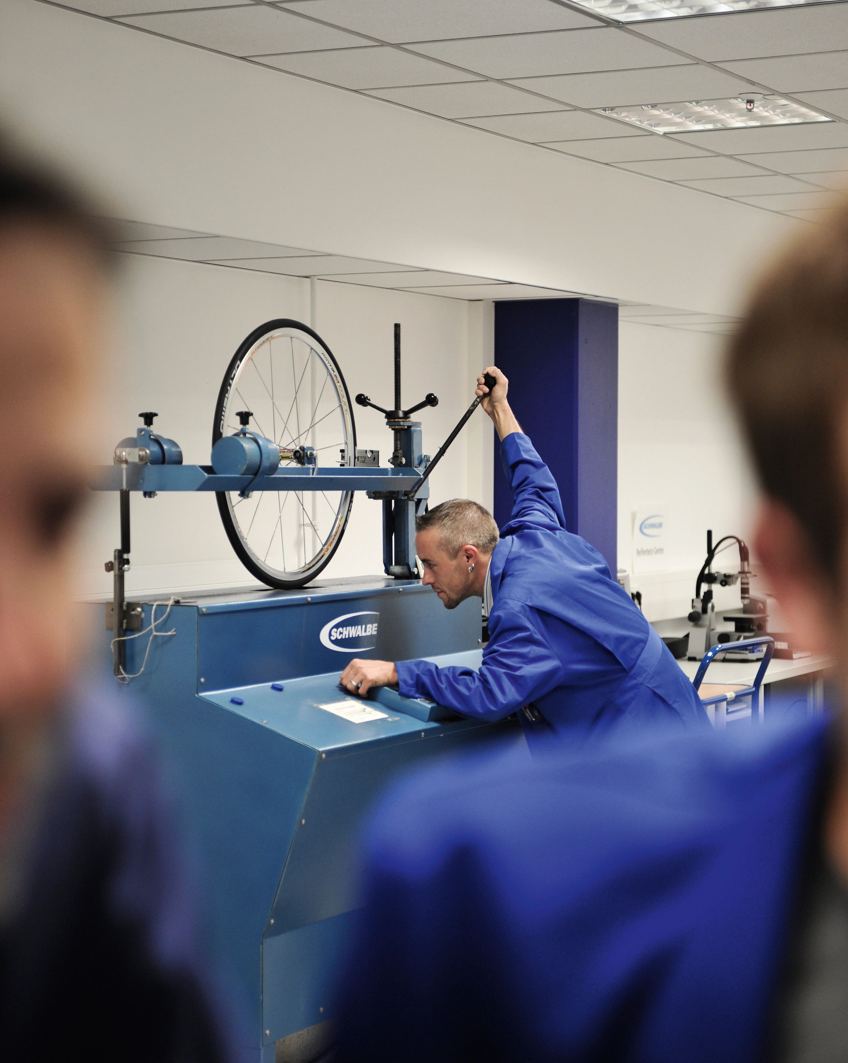 Schwalbe‑Mitarbeiter prüft Fahrradreifen auf Testmaschine – Qualitätssicherung und Entwicklung innovativer Reifenlösungen im Schwalbe‑Labor.