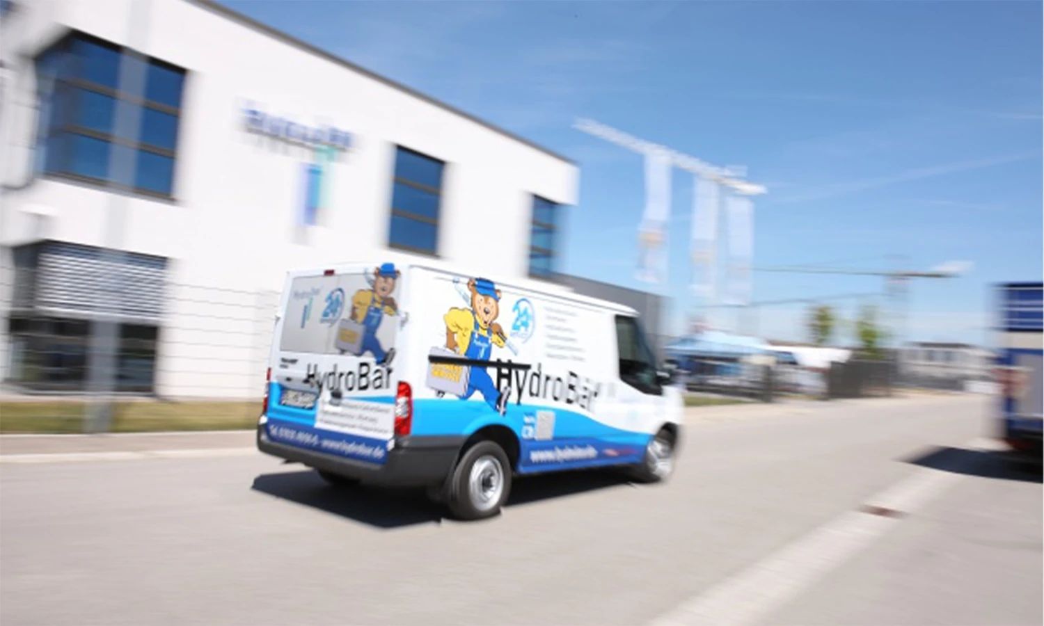 Servicefahrzeug von HydroBar vor dem Unternehmenssitz – Lieferwagen mit Unternehmenslogo, Symbol für mobile Hydraulik‑ und Druckluft‑Services.