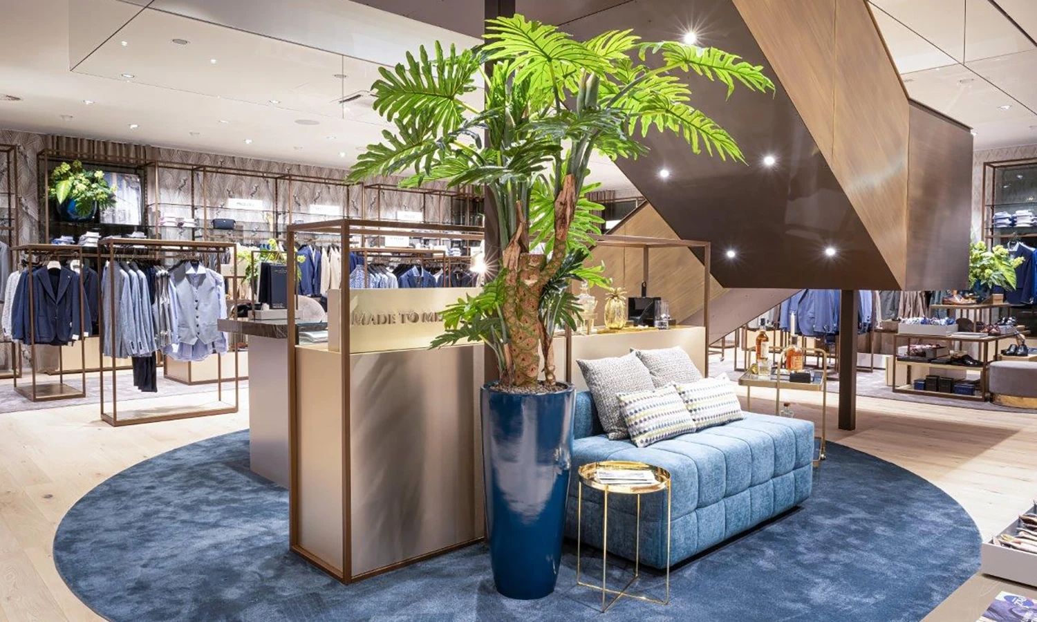 Innenansicht eines PKZ‑Stores – stilvolles Modegeschäft mit moderner Einrichtung, hochwertiger Herrenmode und Lounge‑Bereich für persönliche Beratung.